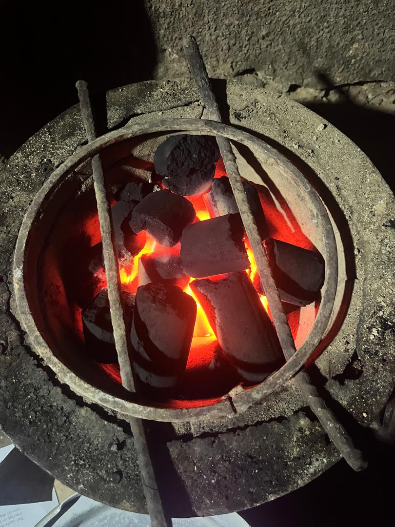 Green Flame briquettes burning in a traditional cooking stove